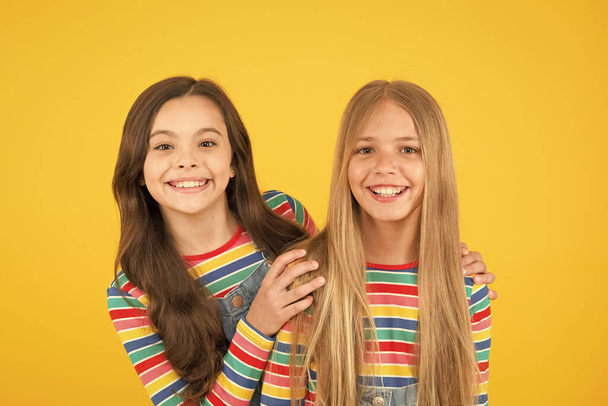 Long hair best female adorn. Girls blonde and brunette shiny healthy hair. Hair strengthening. Grow hair. Hairdresser salon. Kids beautiful friends or sisters with perfect hairstyles. Natural beauty - Zdjęcie, obraz