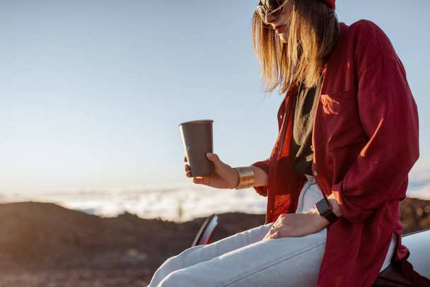 Woan con café en el techo del coche sobre las nubes
 - Foto, imagen