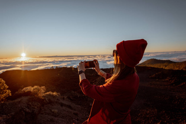 Γυναίκα που ταξιδεύει πάνω από τα σύννεφα σε ένα ηλιοβασίλεμα - Φωτογραφία, εικόνα