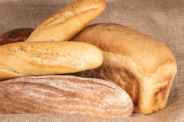 ψημένο ψωμί και μπαγκέτα σε ξύλινο τραπέζι φόντο. - Φωτογραφία, εικόνα