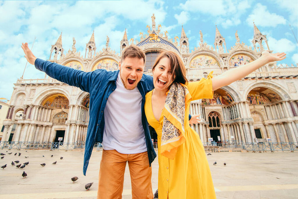 νεαρό όμορφο ζευγάρι που ποζάρει μπροστά από την Βασιλική της Ιταλίας. έννοια καλοκαιρινές διακοπές - Φωτογραφία, εικόνα