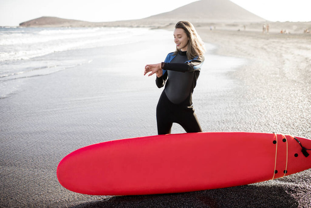 Молодой серфер с доской для серфинга на пляже
 - Фото, изображение