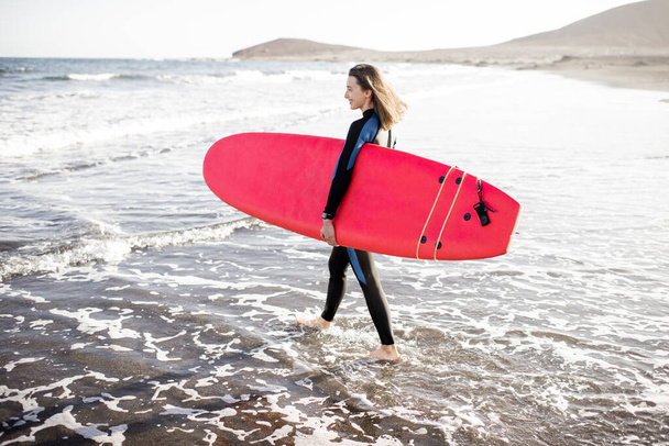 Joven surfista con tabla de surf en la playa
 - Foto, imagen