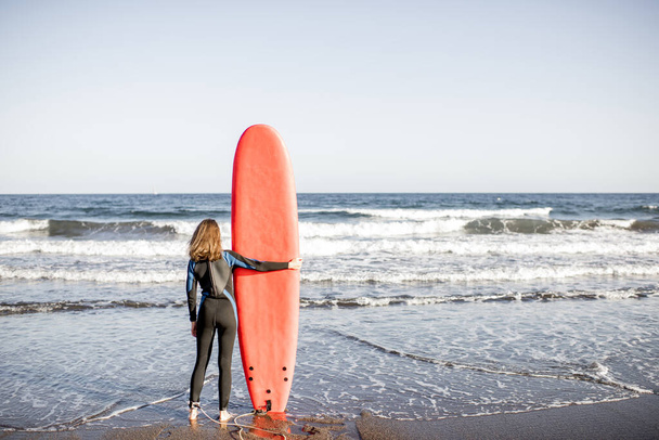 Giovane surfista con tavola da surf sulla spiaggia
 - Foto, immagini