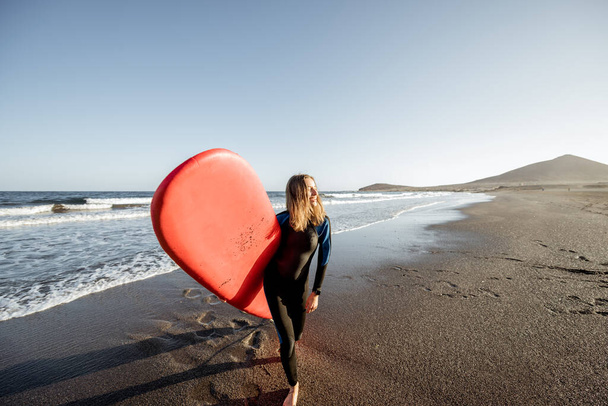 vrouw met surfplank op het strand - Foto, afbeelding