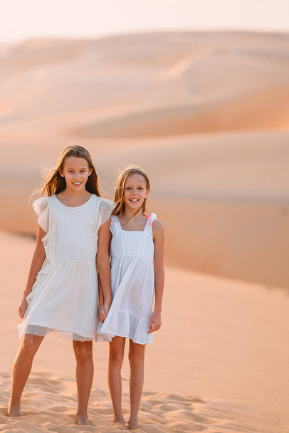 Birleşik Arap Emirlikleri 'nde Rub al-Khali çölündeki kum tepeleri arasında yaşayan kızlar - Fotoğraf, Görsel