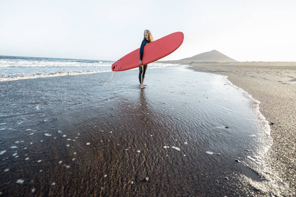 Fiatal szörfös szörfdeszkával a strandon - Fotó, kép