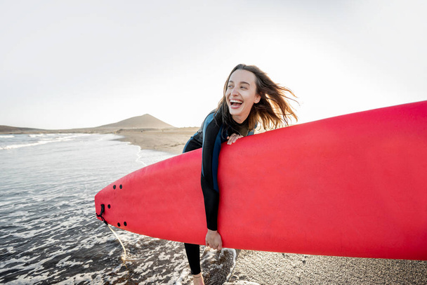 Jovem surfista com prancha na praia
 - Foto, Imagem