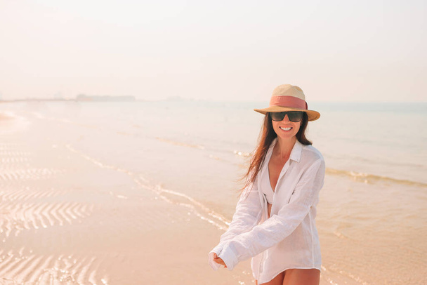 Frau liegt am Strand und genießt den Sommerurlaub mit Blick aufs Meer - Foto, Bild