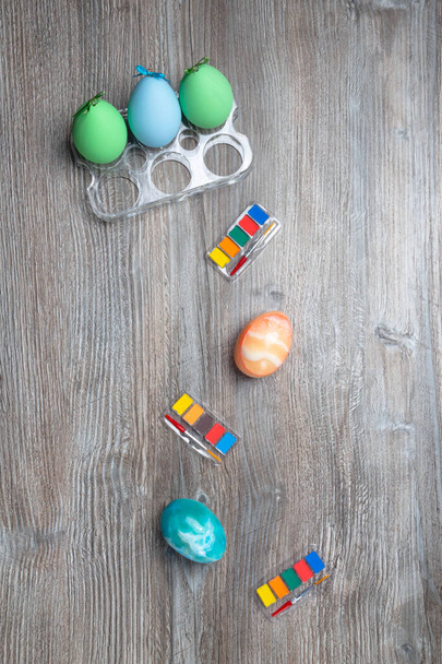 easter eggs and colorful paints and brushes on wooden background. Beginning to painting. Copy space - Foto, afbeelding