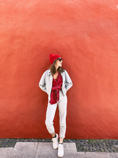 Woman on the red wall background - 写真・画像