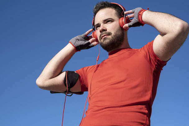 jeune homme se préparant à courir avec une paire d'écouteurs
 - Photo, image