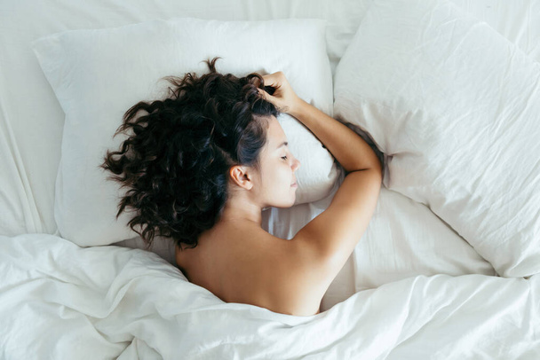woman sleeping in bed bright light on face morning time - Fotoğraf, Görsel