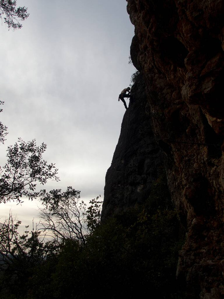 silhouette of a climber on an overhanging rock  in the sunset - Photo, Image