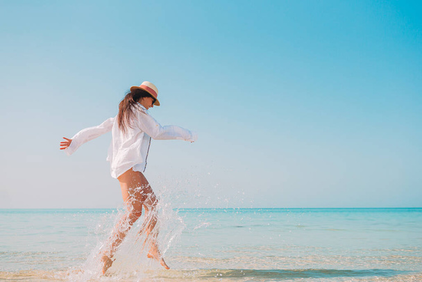 Plajda uzanan kadın yaz tatilinin tadını çıkarıyor ve denize bakıyor. - Fotoğraf, Görsel