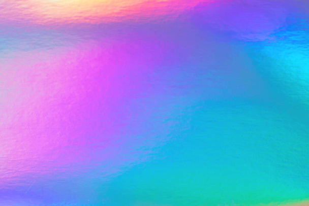 Abstract trendy rainbow holographic background in 80s style. Blurred texture in violet, pink and mint bright neon colors. - Photo, Image