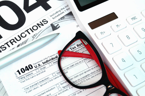 Formulaire d'impôt avec instructions, calculatrice et lunettes. Concept de finance. Délai fiscal rappel
. - Photo, image