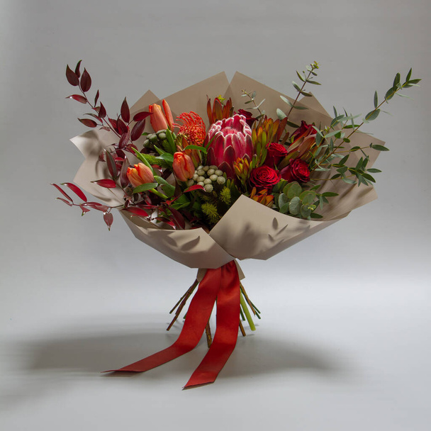 Magnifique bouquet de tulipe, leucospermum, leucadendron, protea, rose sur fond gris, mise au point sélective
 - Photo, image
