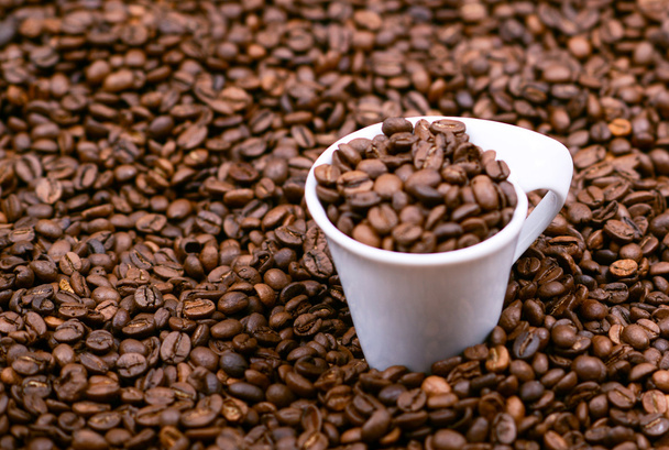 Cup filled with coffee beans - Foto, afbeelding