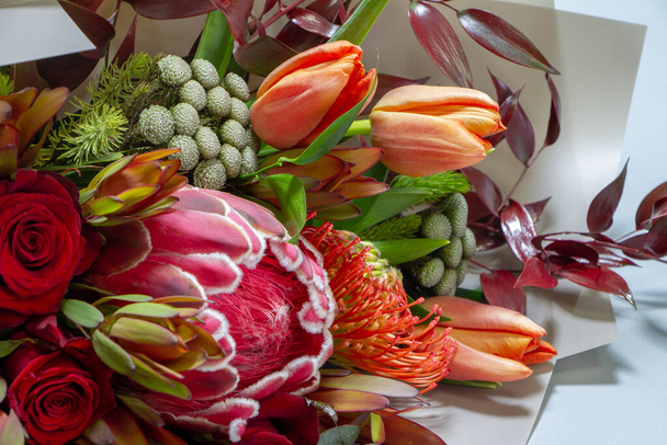 Szczegóły zbliżenie wspaniały bukiet tulipan, leucospermum, leucadendron, protea, róża na szarym tle, selektywne skupienie - Zdjęcie, obraz