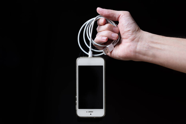 Homme tenant smartphone avec écran vide isolé sur fond noir. Mains masculines avec téléphone, espace pour le texte
 - Photo, image