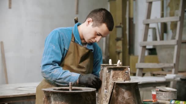 Concrete industry - young man working with concrete details in the workshop - adding screws to it - Video