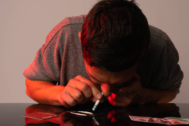 Junkie Mann inhalierte Kokain vom Tisch mit Dollar. Soziales Desaster und Epidemie des Suchtkonzepts - Foto, Bild
