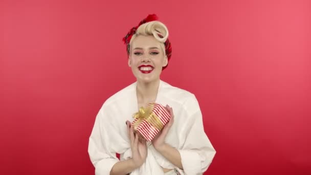 Laughing pin up woman showing gift to camera - Footage, Video