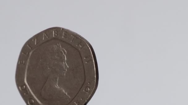 Монета достоинством 20 пенсов 1982 года, вращающаяся на белом фоне - Кадры, видео