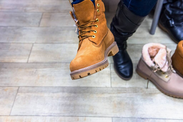 Frau mit Schuhen in einer Bekleidungsboutique. Gelber Schuh zu Fuß - Foto, Bild