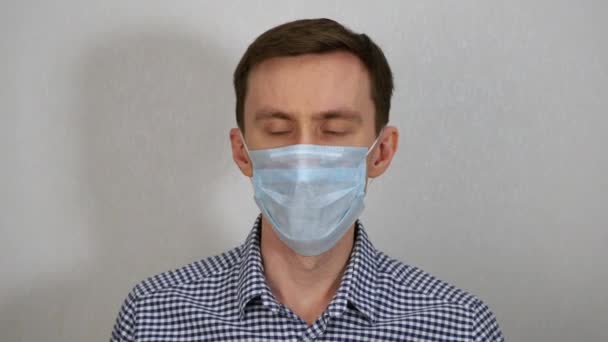 A young man coughs in a medical mask. - Felvétel, videó