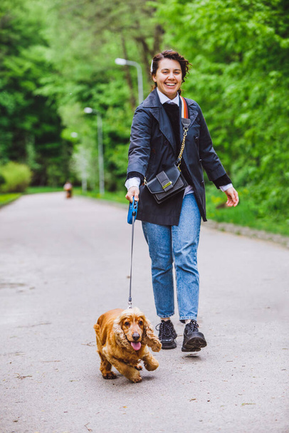 Tasmalı köpek cocker spaniel ile yürüyen bir adam - Fotoğraf, Görsel