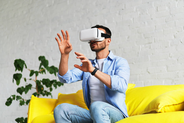Hombre con gafas 3D auriculares de realidad virtual jugando y atrapando algo
 - Foto, imagen