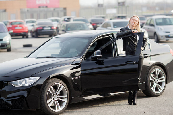 Młoda szczęśliwa kobieta kupiła nowy nowoczesny samochód - Zdjęcie, obraz