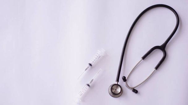 medizinisches Gerät, das auf dem Bild eines Spritzen-Stethoskops mit weißem Hintergrund zu sehen ist - Foto, Bild