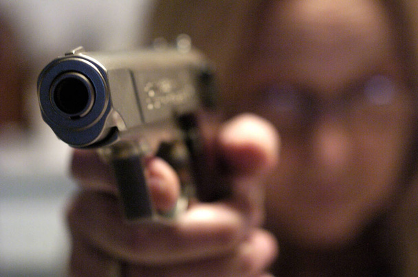 close up of a man's hand holding a gun - Фото, изображение