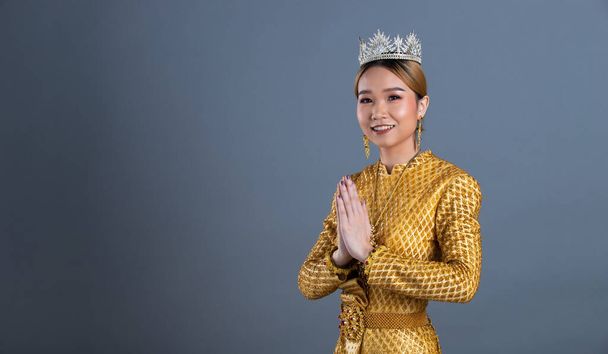 Miss Pageant Diamond koruny thajské tradiční kostým nebo jihovýchodní Asie zlaté šaty v asijské ženy s dekorací póza vlna ruka portrét v mnoha pózách pod Studio osvětlení šedé pozadí - Fotografie, Obrázek