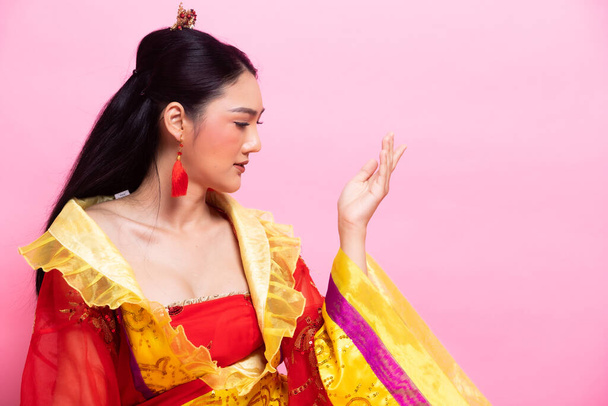 Червоне золоте мереживо китайської традиційної костюмованої опери або Південно-Східної Азії Реддіш-сукня в азіатській жінці з декоративним портретом в багатьох положеннях під Studio Light Pink background, колаж групи - Фото, зображення
