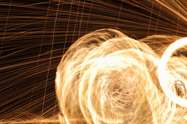 Homme de haute compétence jouant feux d'artifice en tournant le poteau de bois avec le mazout et le feu, cercle autour comme anneau de feu sur la plage le long de l'océan dans l'île tropicale, long mouvement de flou d'exposition élevée
 - Photo, image