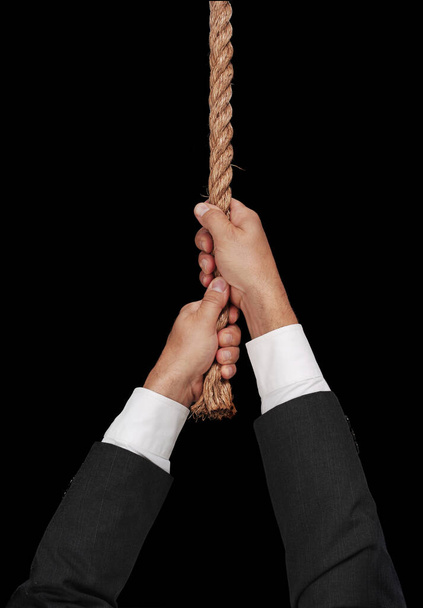 hands pulling a rope on black background - Foto, Imagem