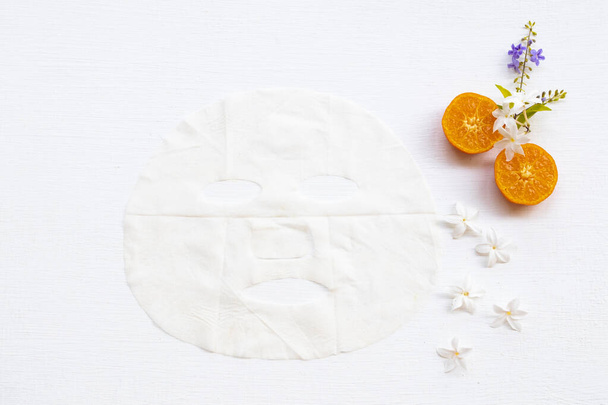 natural aroma sheet mask extract fruit orange health care for skin face essence face mask and flower arrangement flat lay style on background white - Photo, Image