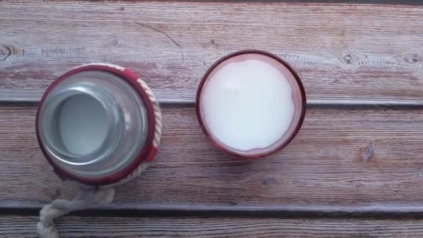 vrchní pohled na sklenici mléka a láhev mléka na stole  - Záběry, video