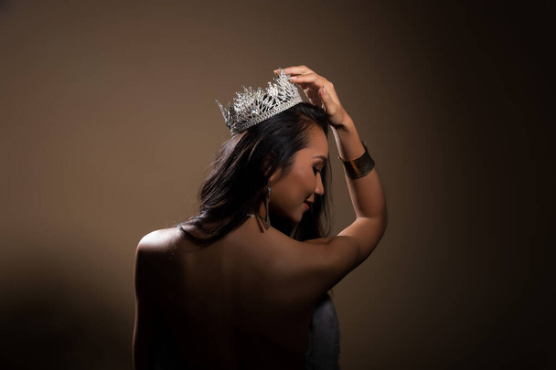 Портрет Miss Pageant Beauty Contest у вечірній сукні з блискучим світлом Діамантова корона, азіатська жінка стиль волосся, поверніть ззаду, не дивіться ні на що - Фото, зображення