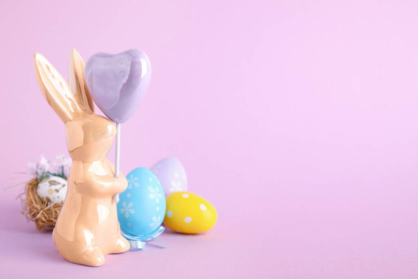 Composition with Easter bunny figure on violet background. Space for text - Фото, зображення