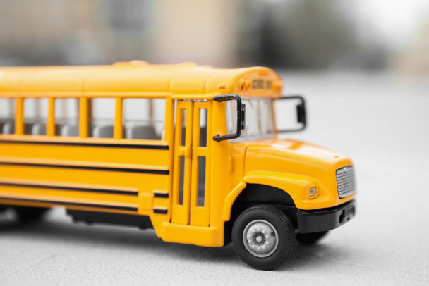 Żółty autobus szkolny zabawki na niewyraźne tło, zbliżenie. Transport dla studentów - Zdjęcie, obraz