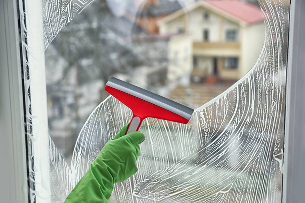 Woman cleaning window with squeegee indoors, closeup - Photo, Image