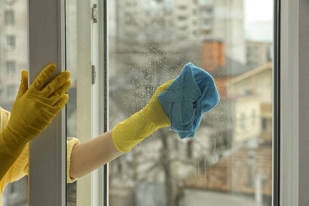 Woman cleaning window at home, closeup view - Valokuva, kuva