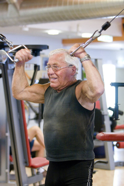 old senior man with white hair doing exercises in gym - Foto, Bild