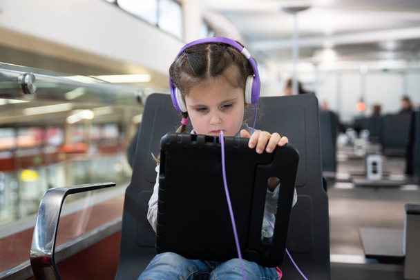 Little Girl In Headphones Playing With Tablet At Airport - Fotoğraf, Görsel