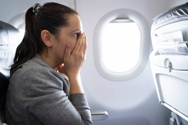 Young Woman Having Anxiety Attack In Airplane - 写真・画像